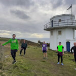 group of runners in front of tower
