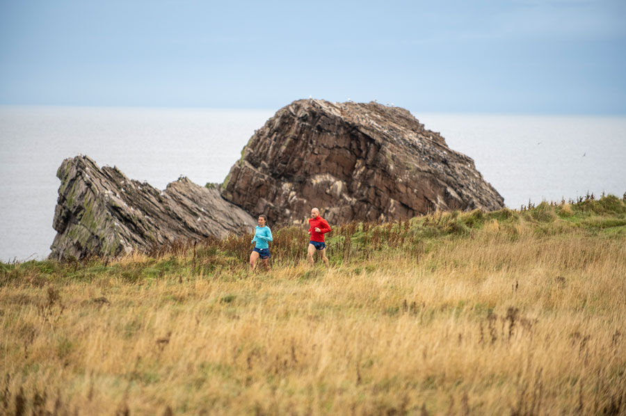 two runners running past bow fiddle rock