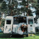 A lady hangs out the back of a caravan