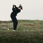 A person golfing in the rain