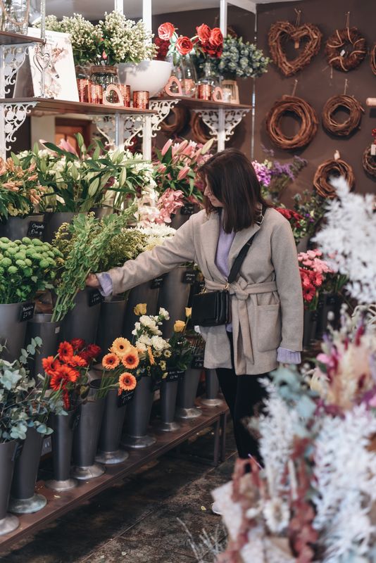 A lady looks at flowers in a shop