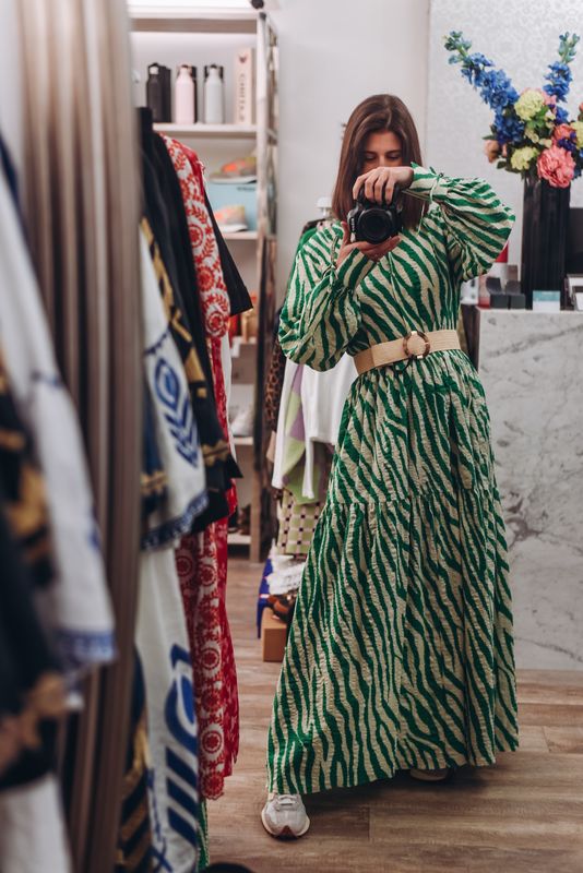 A lady tries on a green dress