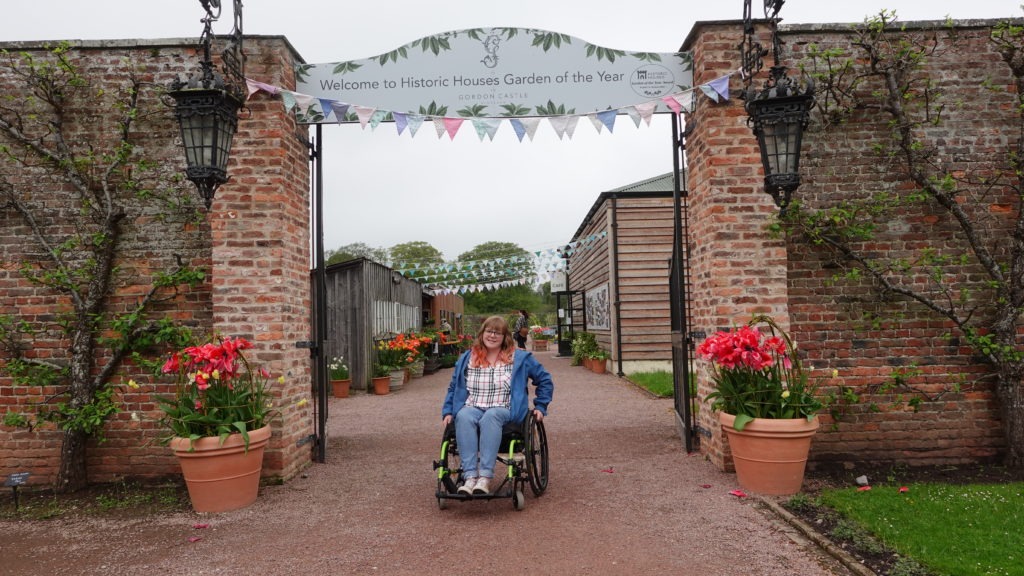 A lady in a wheelchair outside of Gordon Castle Walled Gardens