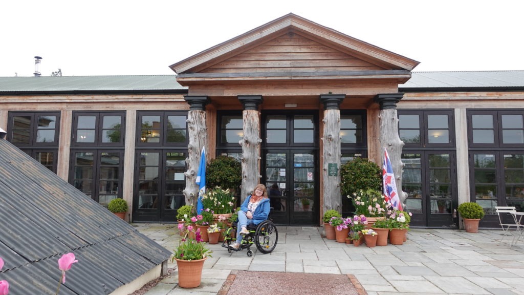 Photo of a lady in a wheelchair outside a building