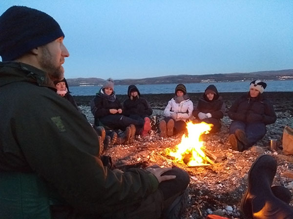 Picture of people around campfire on a beach